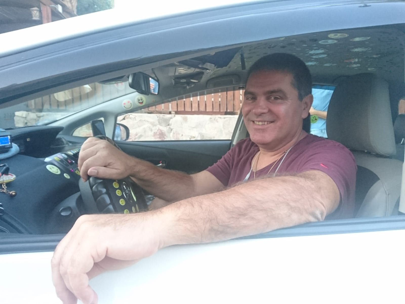 נהג של אילת טקסי מחייך ברכב